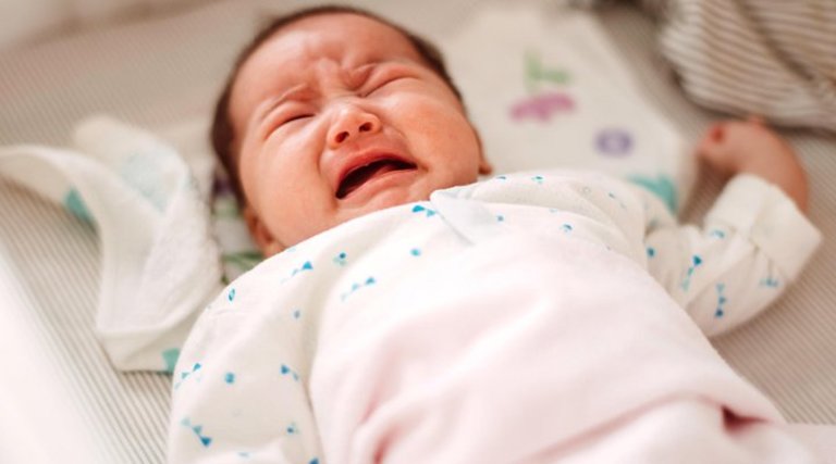 Trẻ hay quấy khóc, bụng phình to và cứng là một trong những biểu hiện thường thấy của trẻ sơ sinh bị táo bón lâu ngày